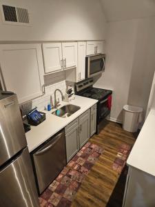 a small kitchen with a sink and a refrigerator at Lofty Haven, your home away from home! in Huntsville
