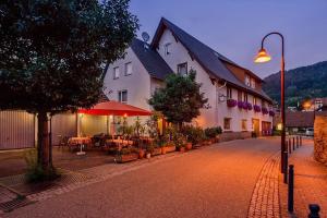 a street with a building and tables and a street light at Landgasthaus waldhorn in Forbach