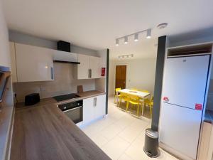 una cocina con armarios blancos y una mesa con sillas amarillas en Secluded and spacious apartment, en Dublín