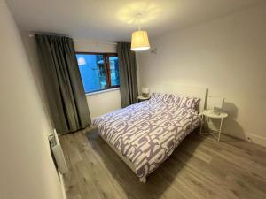 Habitación pequeña con cama y ventana en Secluded and spacious apartment, en Dublín