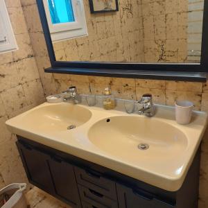 uma casa de banho com um lavatório e um espelho em Etxe Laminak em Sisteron