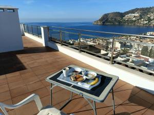 una bandeja de comida en una mesa en un balcón en Apartamento Maravilla Tropical - La Herradura, en Almuñécar