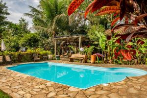 uma piscina no meio de um jardim em Casa da Praia em Paraty