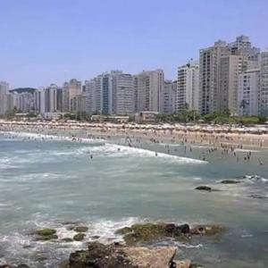 una playa con un montón de gente en el agua en 03 Doutor Hostel 800mts da praia en Guarujá