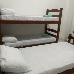 two bunk beds in a small room withthritisthritisthritisthritisthritisthritisthritisthritis at 03 Doutor Hostel 800mts da praia in Guarujá
