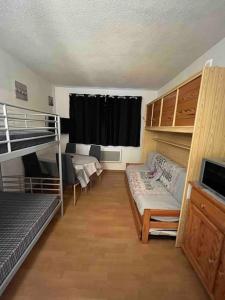 a room with two bunk beds and a couch at Charmant studio à Font-Romeu avec place de parking in Font Romeu Odeillo Via