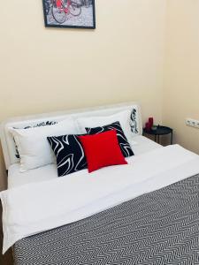 - un lit blanc avec des oreillers en noir et blanc dans l'établissement Like Home Rooms, à Almaty