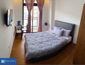 a bedroom with a bed and a table and a window at Studio Tower by KR in Baguio