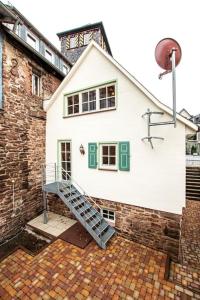 a white house with a staircase in front of it at Torwärterhaus mit Geschichte in Neubulach