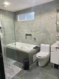 ein Badezimmer mit einer Badewanne, einem WC und einem Waschbecken in der Unterkunft Hermosa Casa con Alberca MC2 - 3 habitaciones max 9 huéspedes in Los Sauces