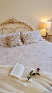 una cama con un libro y una flor en ella en Las Golondrinas de Henche, 
