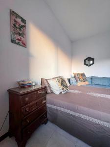 una camera con letto e cassettiera in legno di Apartamento Chill Stay a Oeiras