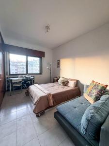 una camera con un grande letto e un divano di Apartamento Chill Stay a Oeiras