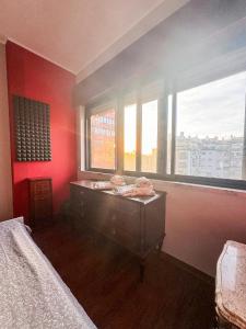 una camera da letto con pareti rosse, un letto e una finestra di Apartamento Chill Stay a Oeiras