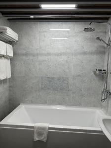a bathroom with a bath tub and a sink at Mir Luxe Plaza in Tashkent
