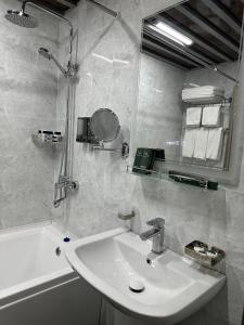 a bathroom with a sink and a mirror and a tub at Mir Luxe Plaza in Tashkent