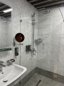a bathroom with a shower and a sink and a tub at Mir Luxe Plaza in Tashkent