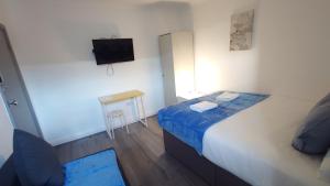 a small bedroom with a bed and a small table at Kings Central Apartments in Kings Cross in London