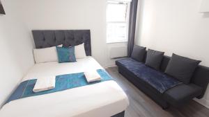a bedroom with two beds and a couch at Kings Central Apartments in Kings Cross in London