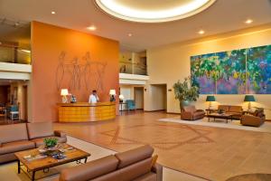 a lobby with furniture and a large painting on the wall at Apartamentos do Lago in Ferreira do Zêzere