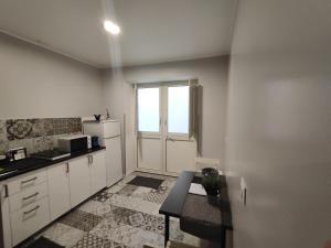 eine Küche mit weißen Schränken, einem Fenster und einem Tisch in der Unterkunft Dante alighieri in Villa Colle Onorato