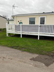 a house with a white fence on a yard at CW27 St Osyth Holiday Park with disability Ramp in Saint Osyth