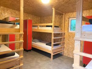 a room with bunk beds in a house at Camping la Faloise 