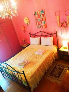 a bedroom with a bed in a room with pink walls at Ζεστό παραδοσιακό σπιτι in Kalamata