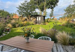 una mesa de madera con un jarrón de flores. en Highfields - Blythburgh en Blythburgh