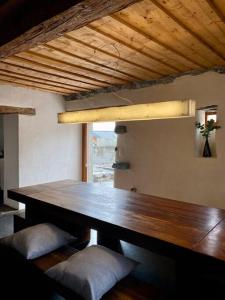 una gran mesa de madera en una habitación con ventana en Maison Alphonse de Mélie, avec cachet., en Conthey