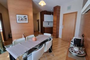 a dining room with a table and chairs and a kitchen at BH & Semiramida Ski Apartment in Borovets