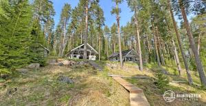 une maison dans les bois avec un chemin en bois dans l'établissement Kalaranta Cottage, à Muurame