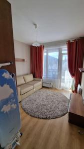 a living room with a couch and red curtains at BH & Semiramida Ski Apartment in Borovets