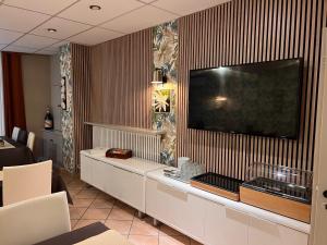 ein Wohnzimmer mit einem großen TV an der Wand in der Unterkunft Hotel Alpes Cevennes in Guilherand