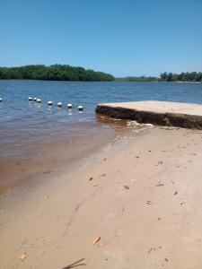 a beach with a row of rocks in the water at Pier Jacuípe Residencial in Camaçari