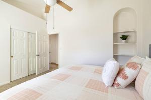 a white bedroom with a bed with pink and white pillows at Stunning 5 Bed Luxury Oasis Heated Pool Hot Tub in Scottsdale