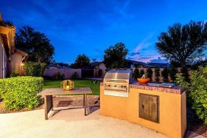 a stove and a picnic table in a backyard at Stunning 5 Bed Luxury Oasis Heated Pool Hot Tub in Scottsdale