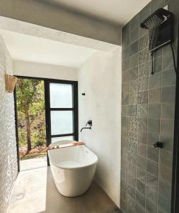 a bath tub in a bathroom with a window at Casa Physis in Capitólio