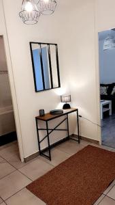 un angolo di una camera con tavolo e specchio di Le Cocon de L'Horme 30 min LYON Parking privé a LʼHorme