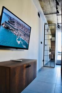 Chic Penthouse industrial-style في موستا: غرفة معيشة مع تلفزيون كبير على الحائط