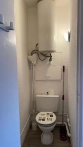 een kleine badkamer met een wit toilet en een tank bij La Méa in Barcelonnette