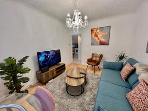 a living room with a blue couch and a tv at Central Cambridge Fig Tree House Flat 1 in Cambridge