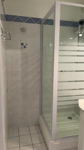een douche met een glazen deur in de badkamer bij La Méa in Barcelonnette