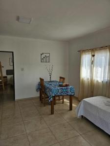 ein Esszimmer mit einem Tisch, Stühlen und einem Bett in der Unterkunft Center Cruz del Eje in Cruz del Eje