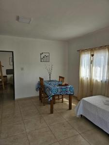 a dining room with a table and chairs and a bed at Center Cruz del Eje in Cruz del Eje