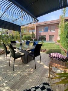 un patio con mesa y sillas en una terraza en Villa Valentina, en Marrakech