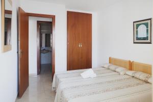 a bedroom with a bed and a wooden door at Suite Apartments Arquus in Salou