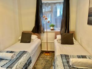 two beds in a small room with a window at Central Cambridge Fig Tree House Flat 1 in Cambridge