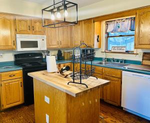 a kitchen with wooden cabinets and a counter top at Spacious Country Home, Hot Tub, Fire Pit, Deck 