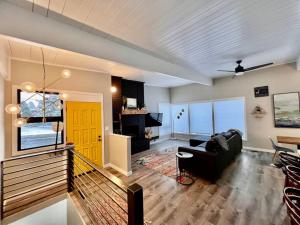uma sala de estar com um sofá e uma porta amarela em Mid Century Modern Montana Dream Home em Butte